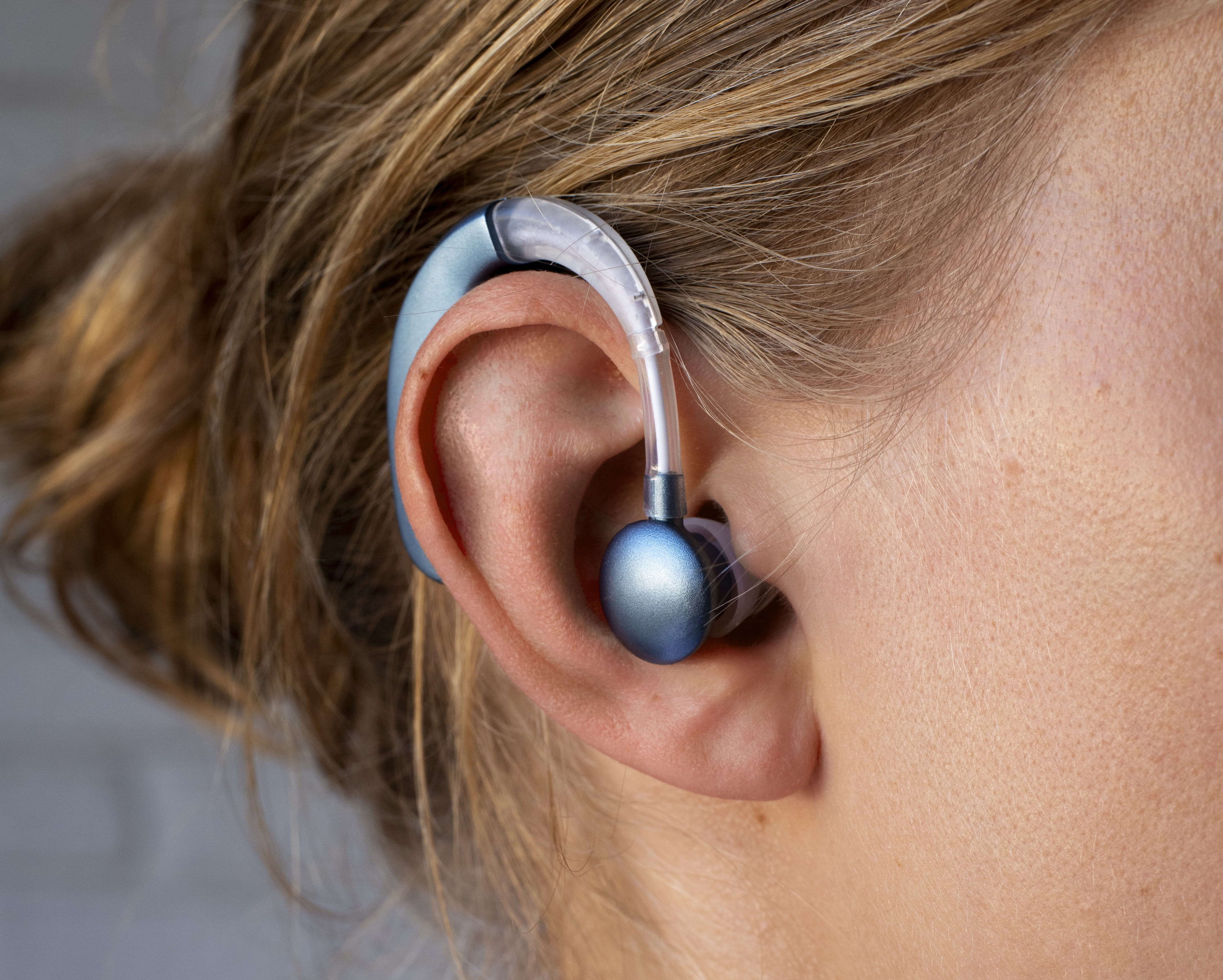 Woman with hearing aid in right ear profile view