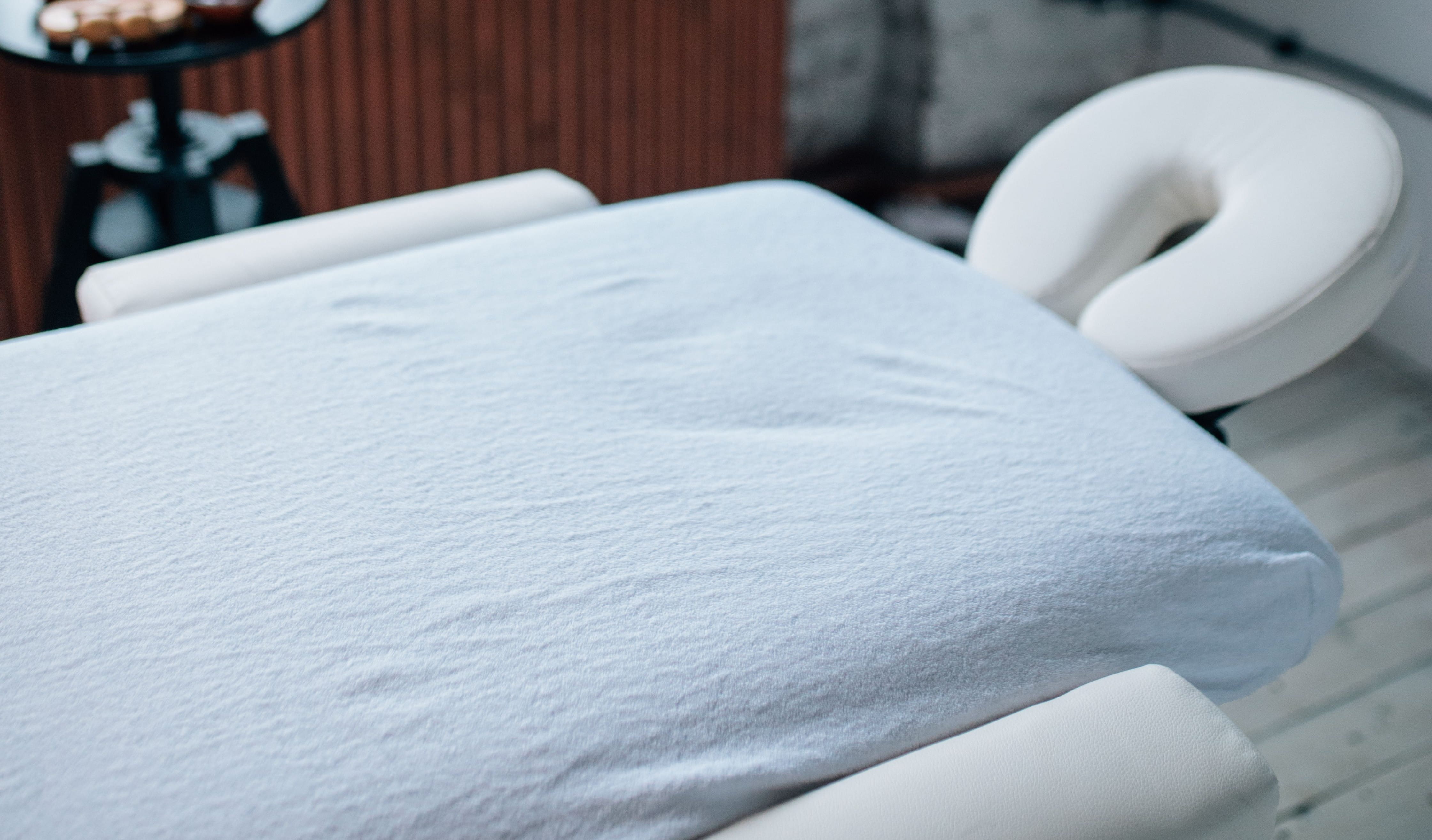 White massage table covered by a white sheet