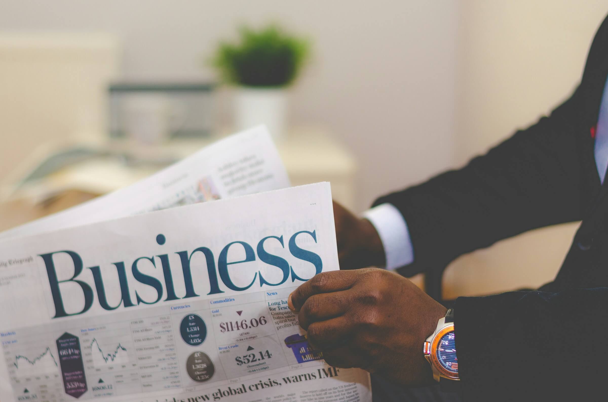 Someone holding the business section of a newspaper