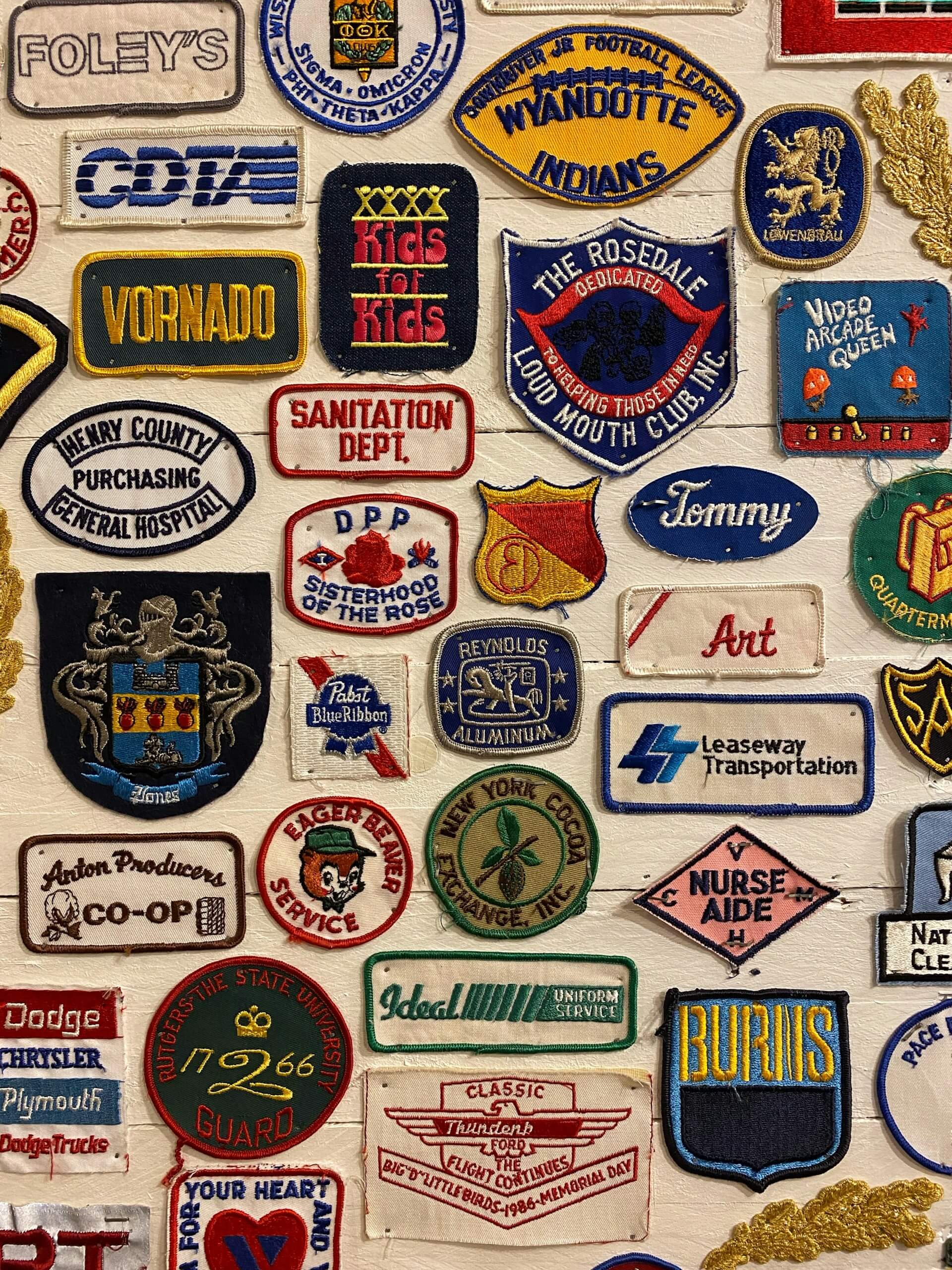 Multiple different logo patches pinned for display on a wall