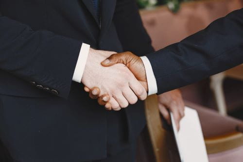 Two Men Shaking Hands in Suits