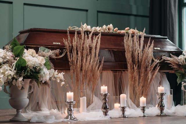 Wooden Casket with White Flowers and White Candles