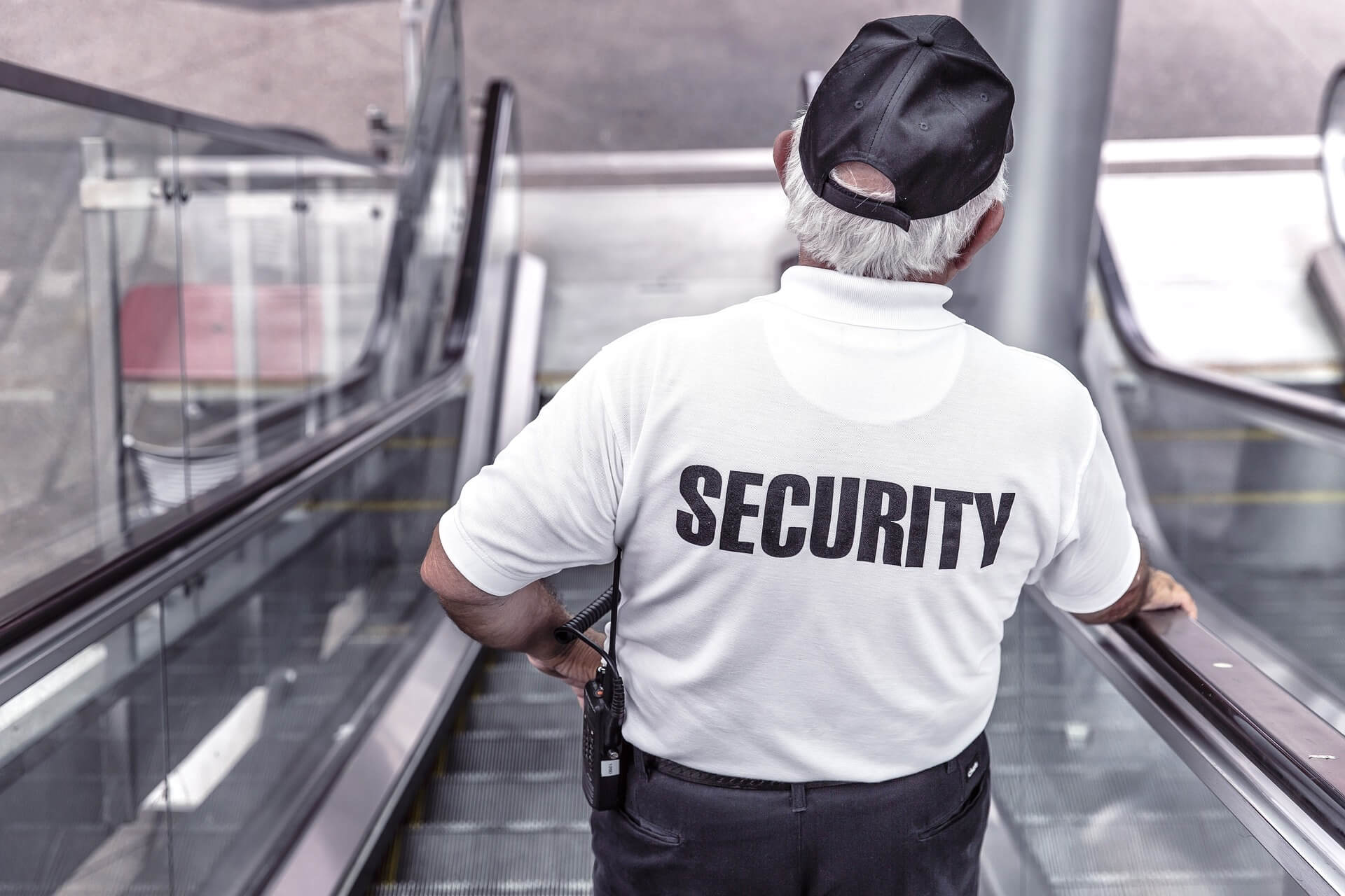 Security guard going down an escalator