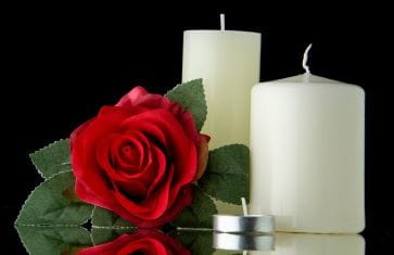 Red Rose and White Candles with a Black Background