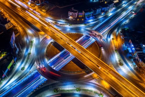 Aerial view of traffic in roundabout and highway at night