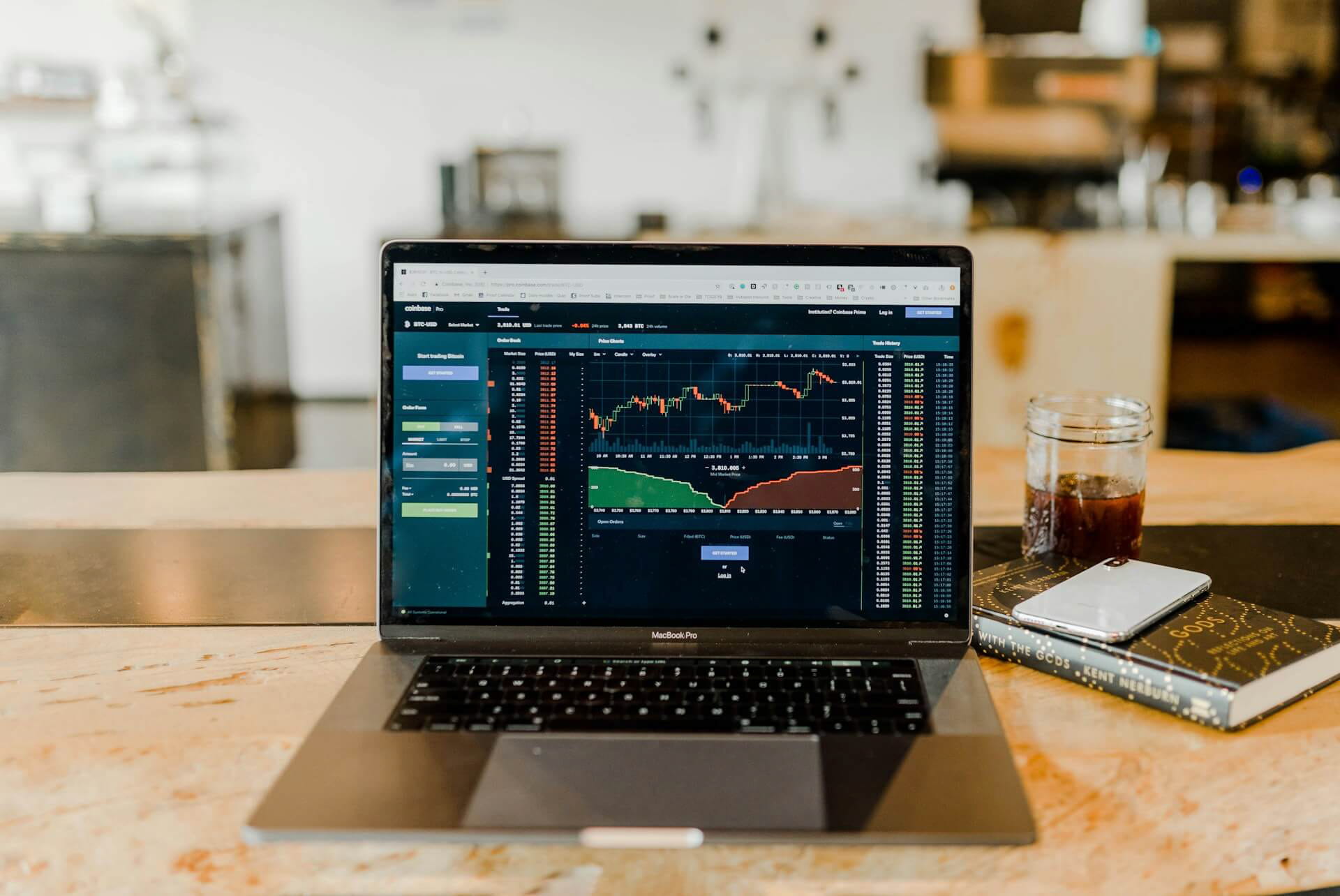 Laptop sitting on a desk displaying trading charts