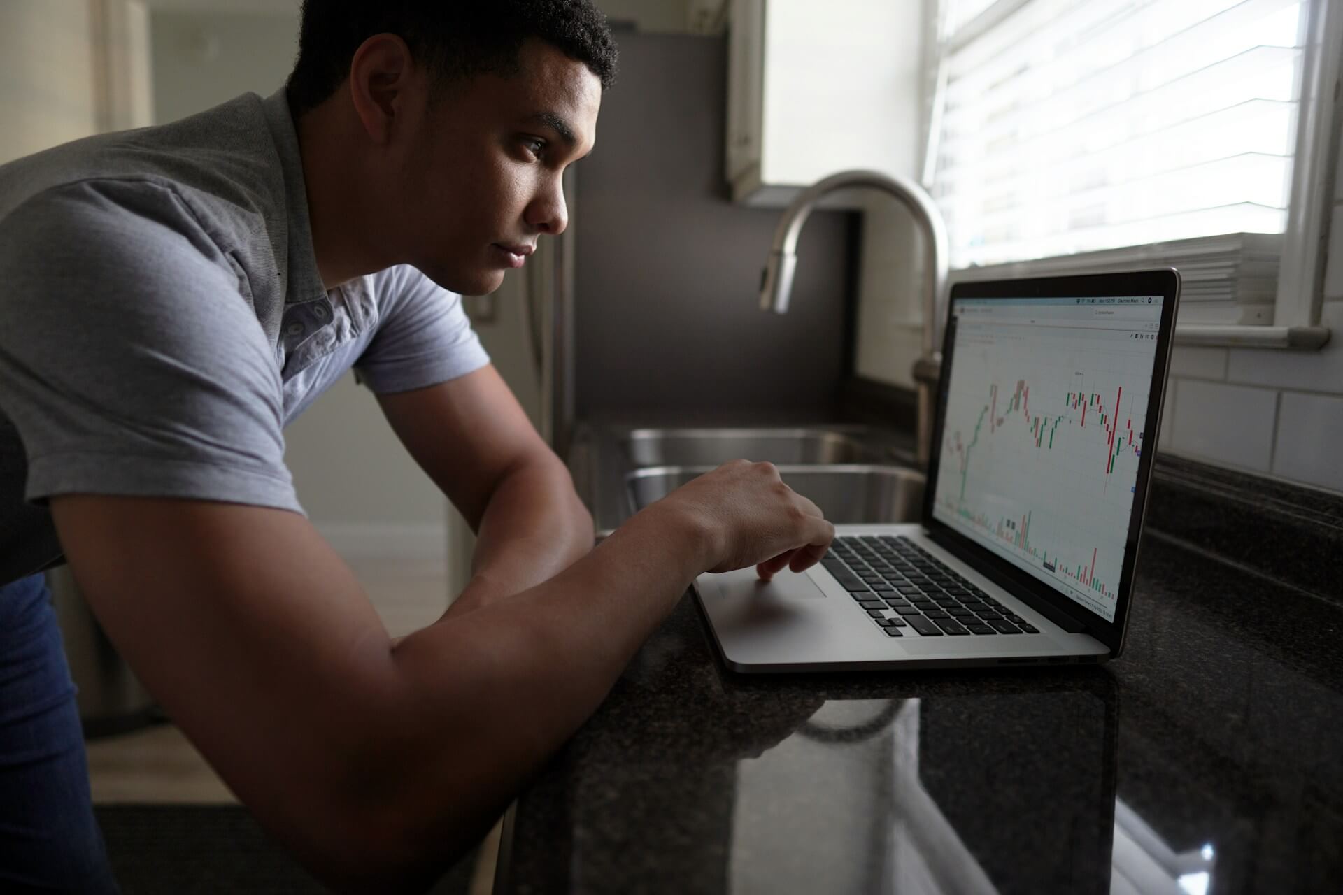 Person using laptop on a kitchen countertop