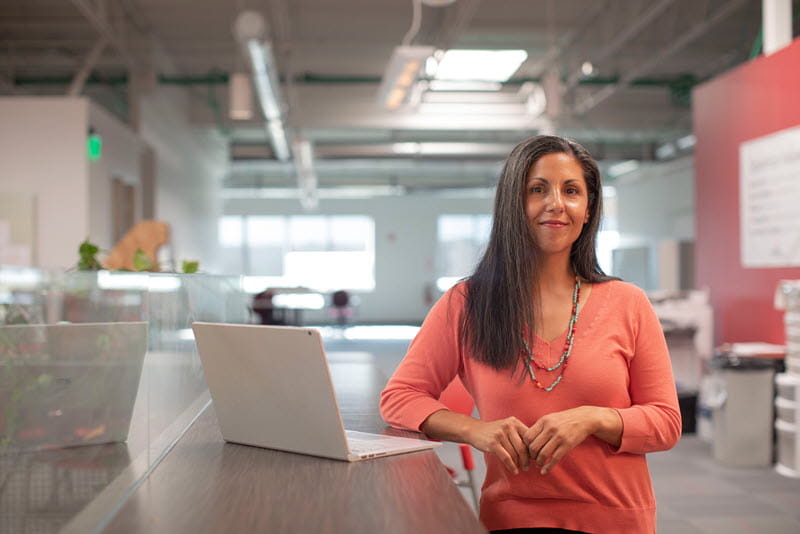 A person standing near a laptop computer