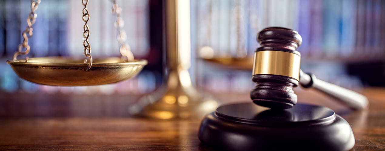 scales of justice and gavel in front of book shelves