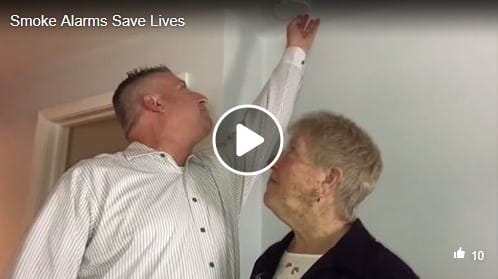 person testing smoke alarm