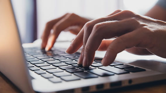 hands typing on a computer