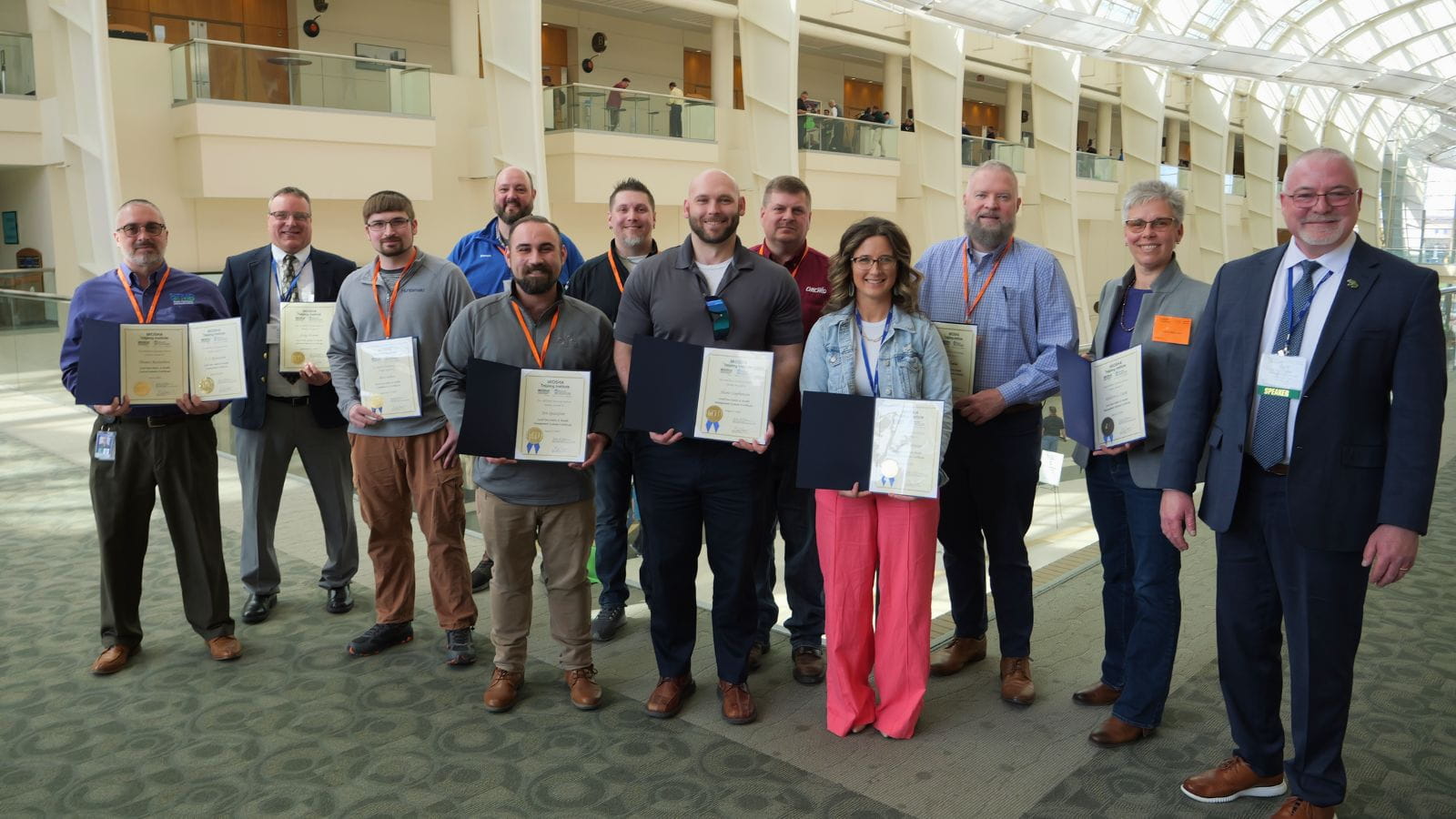 Smiling people holding certificates