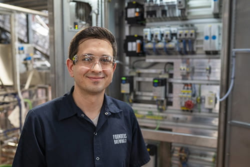 Man with safety glasses on in front of circuit panel