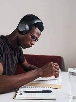 Young man with headphones on studying 