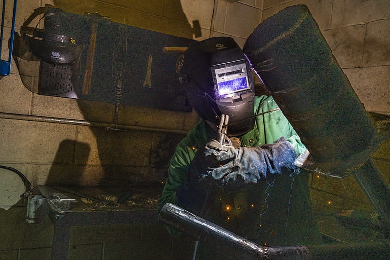A welder welding in a shop.