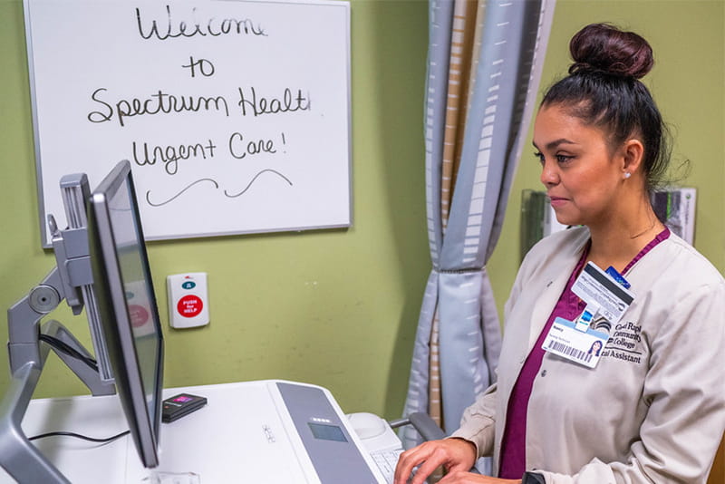 A Spectrum health apprentice working on a computer.