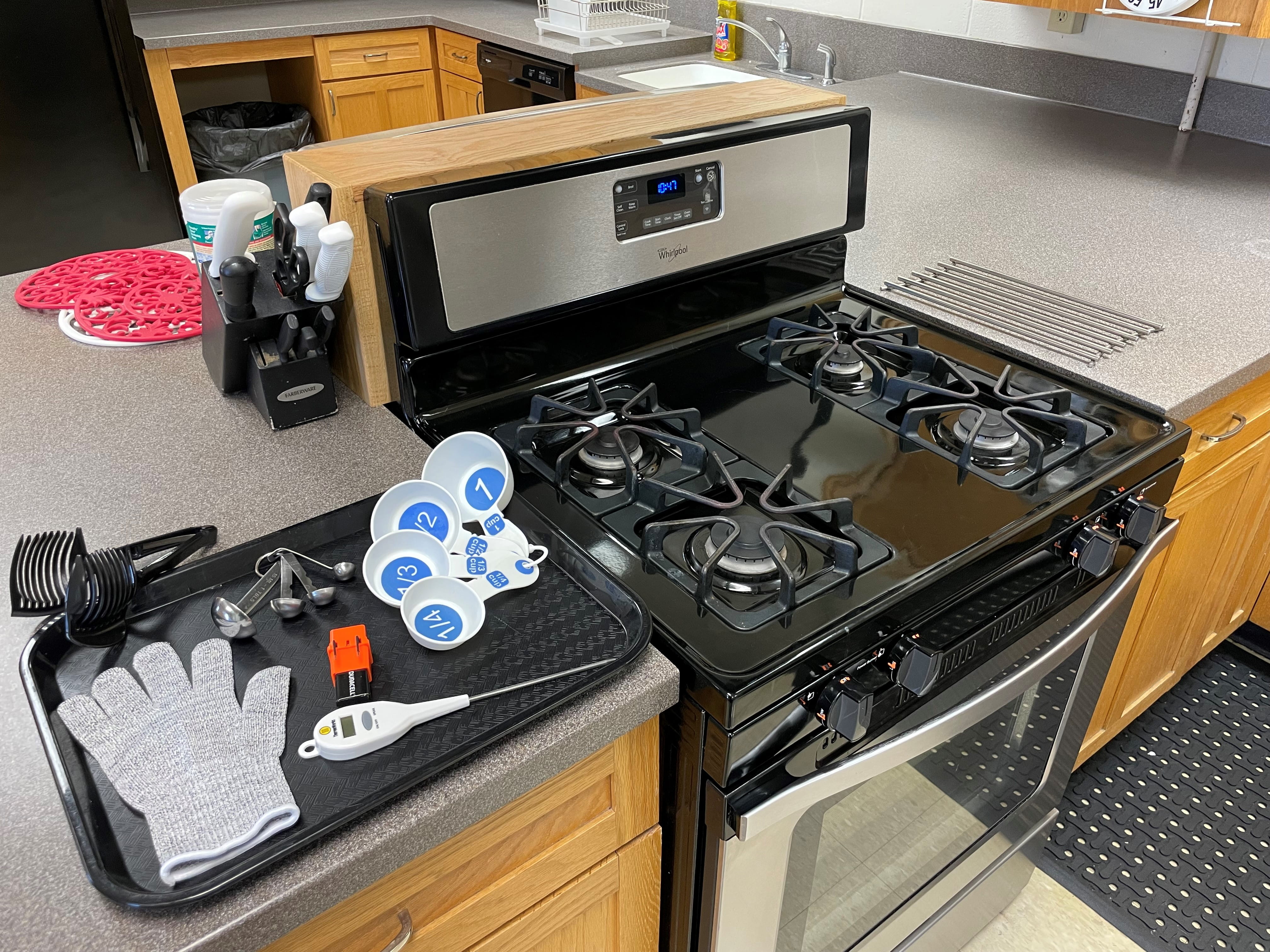 Stove and kitchen items laid out on a counter