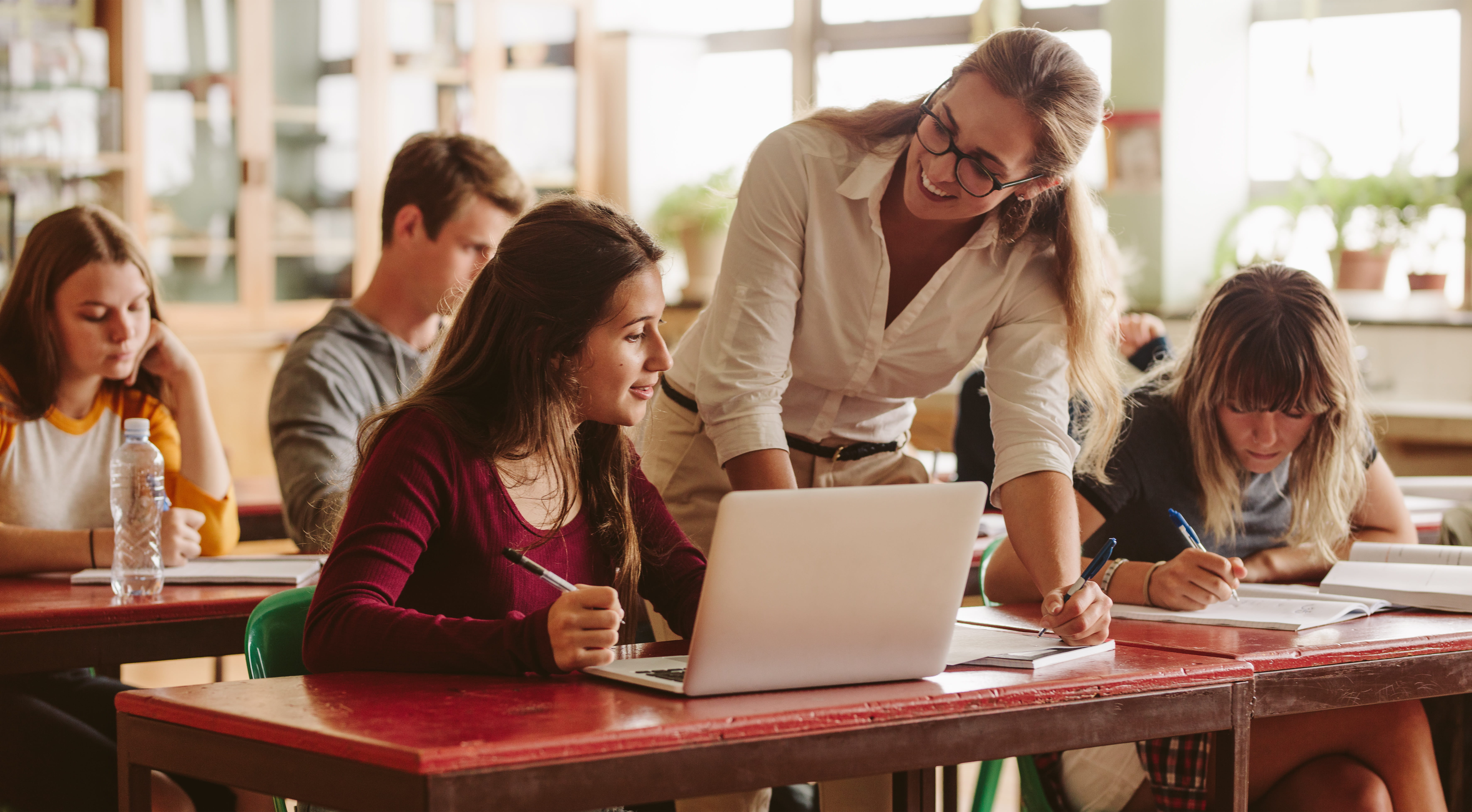 Teacher in a classroom assisting students