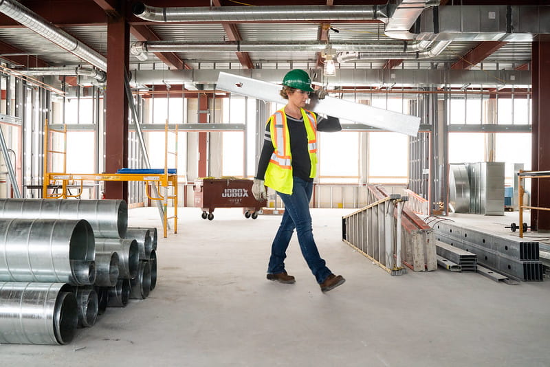 construction worker carrying beam 