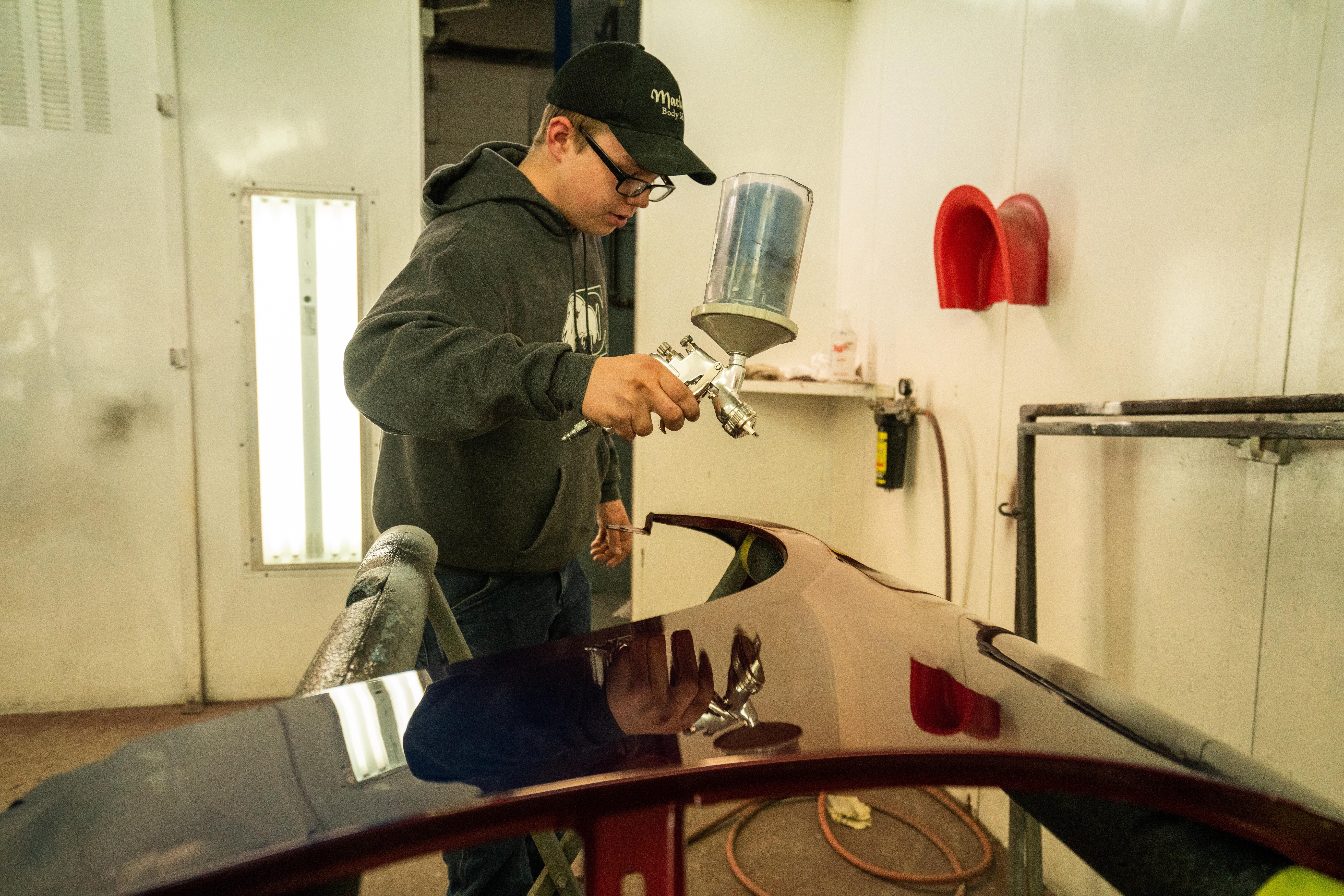 Coby Chatters, senior at Northwest high school painting car parts in his auto collision repair class.