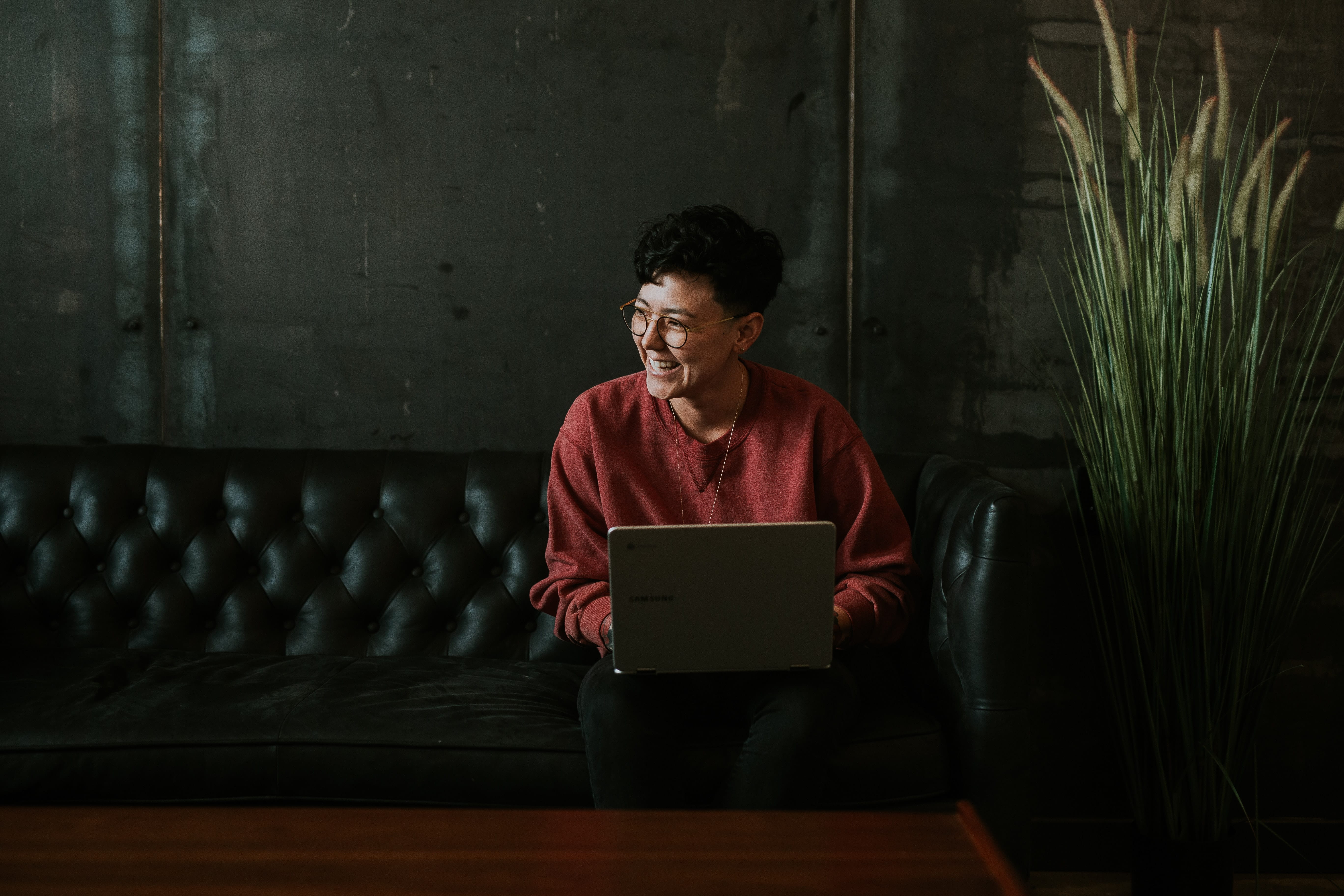 A girl working on her laptop on a couch.