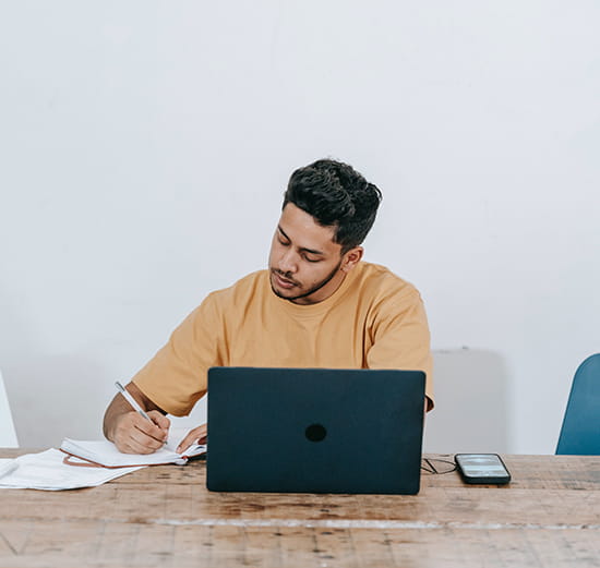 Man in brown shirt working at computer
