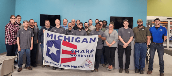 Dewys Manufacturing Employees holding SHARP worksite banner