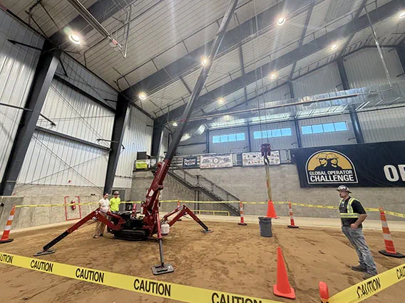 two people standing next to a crane enclosed in caution tape while another person in safety gear looks on