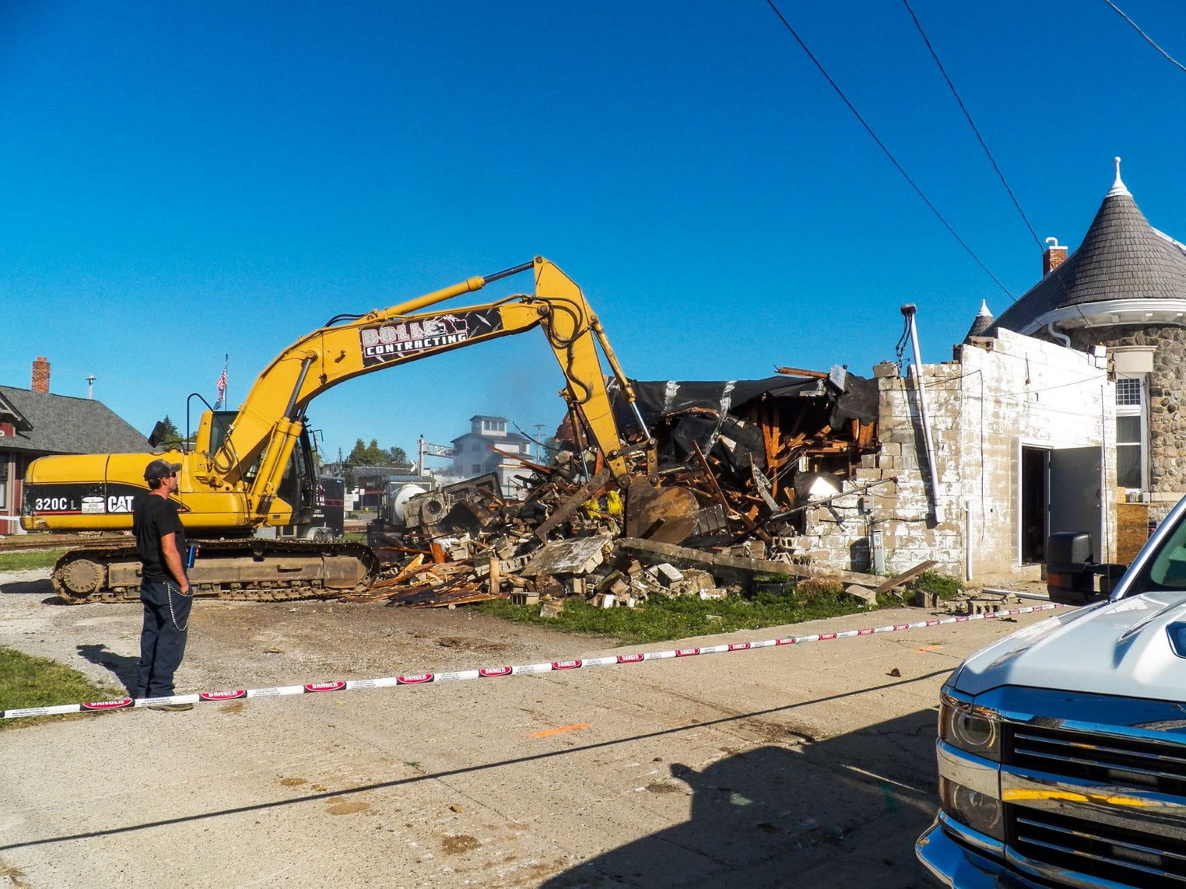 Excavator knocking down a wall of the former laundromat
