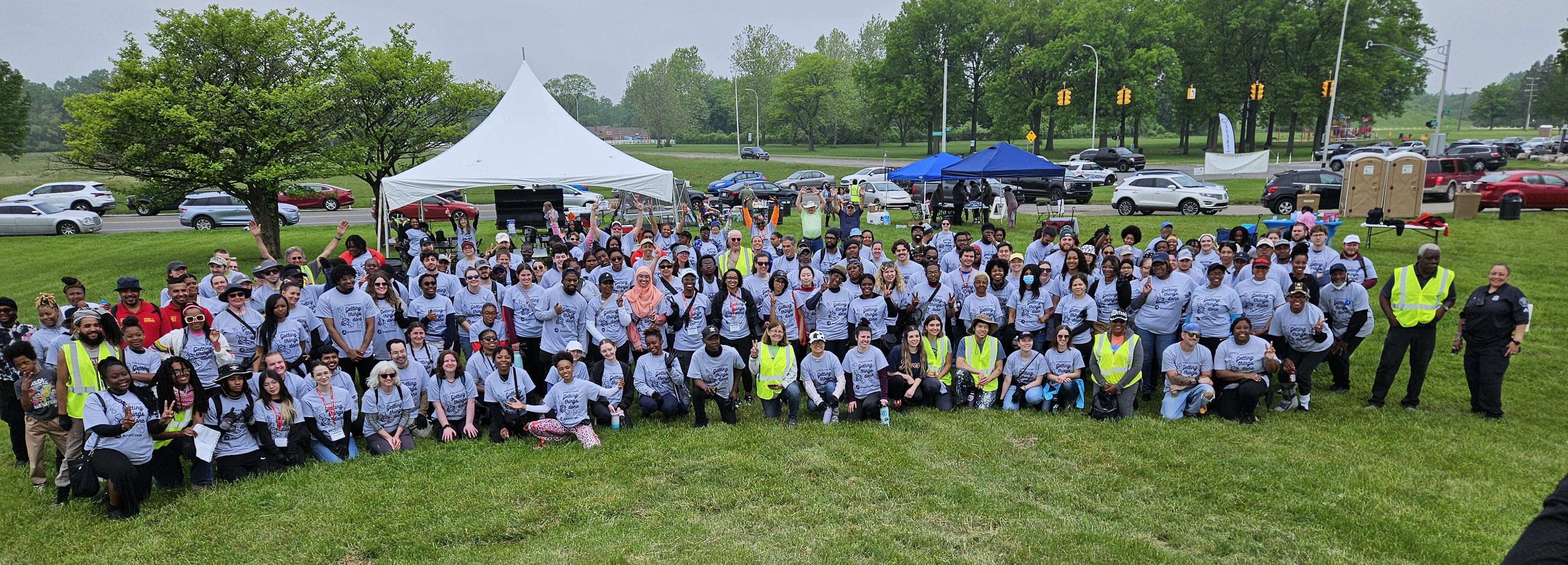 large group of volunteers outside in matching shirts posing for picture