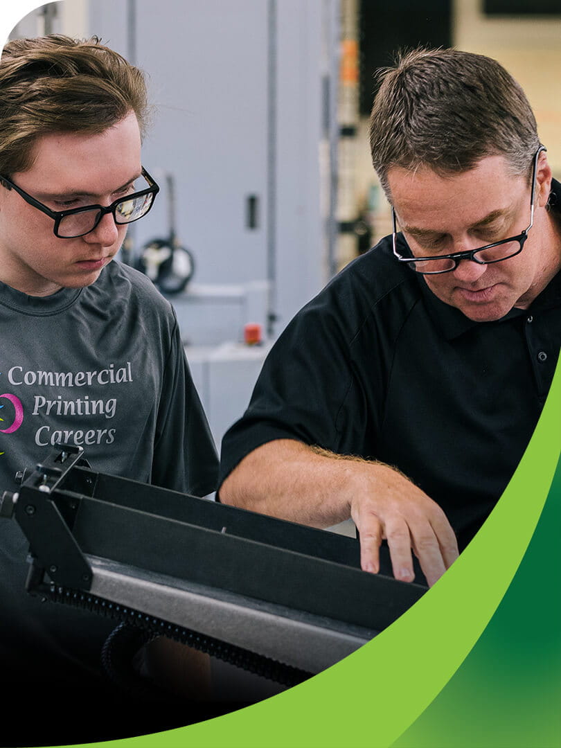 MCTI Commercial Printing instructor working alongside a student to demonstrate how to use a commercial production printer.