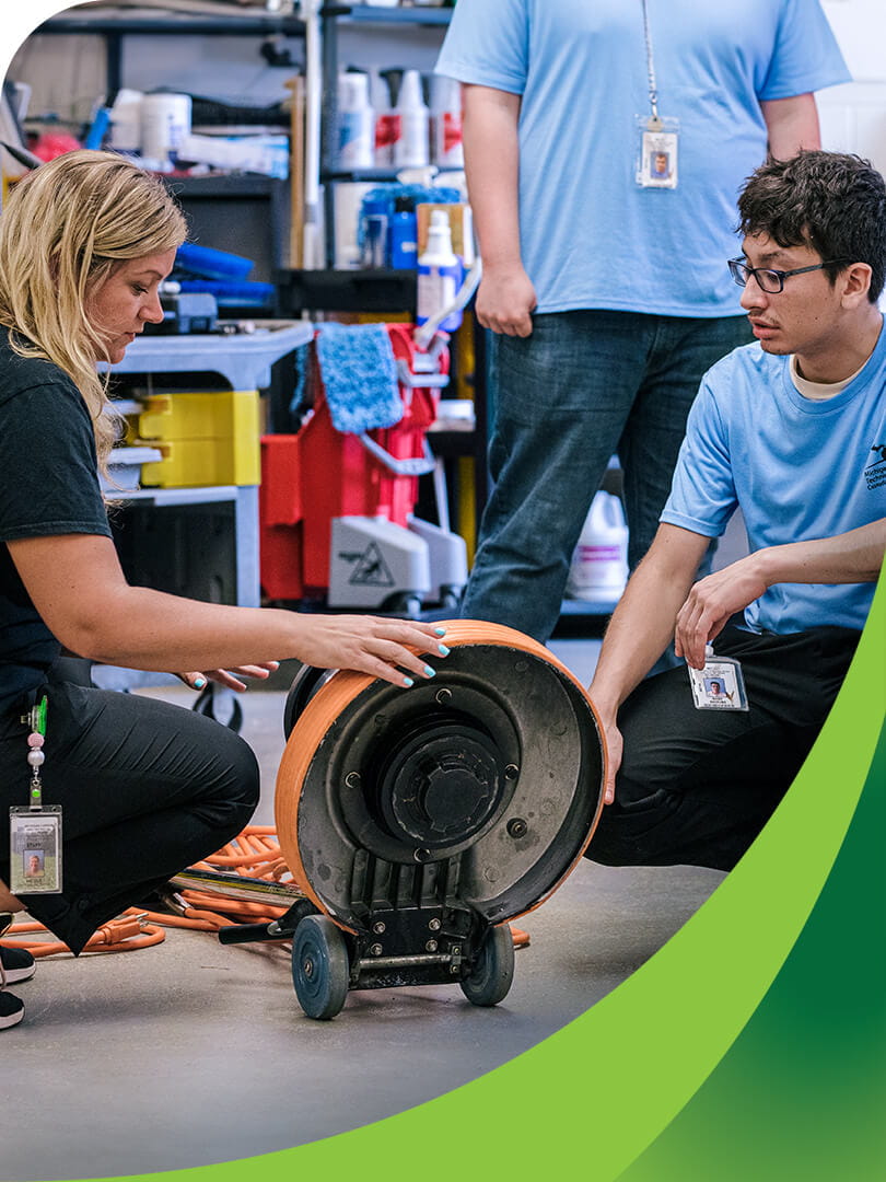 MCTI Custodial instructor demonstrating to students how to inspect a commercial floor buffer.