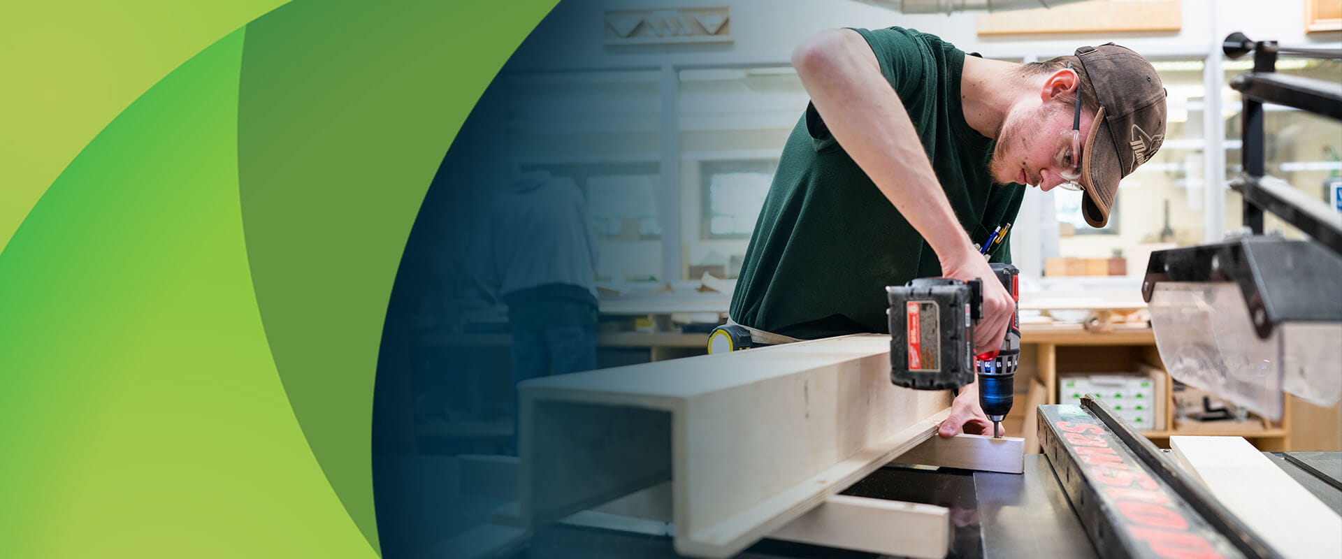 An MCTI student in the Cabinetmaking/Millwork training program wearing safety glasses while using a cordless drill in a woodshop.