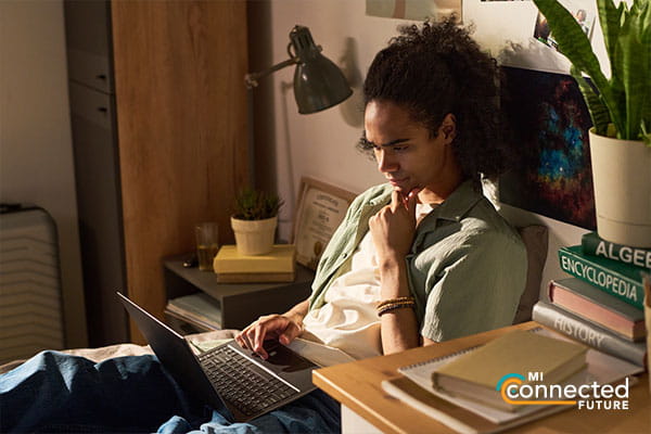 girl sitting in bed using a laptop