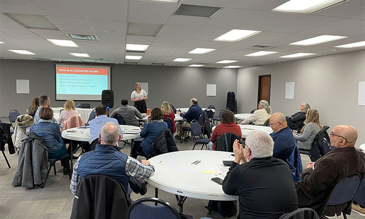 A group of stakeholders listen to a presentation from MIHI during the MI Connected Future Tour