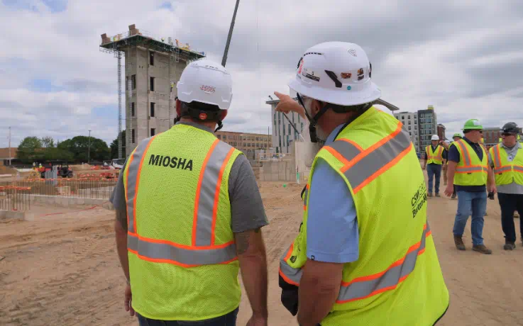 MIOSHA staff and construction workers in safety vests at the Kalamazoo Event Center construction site