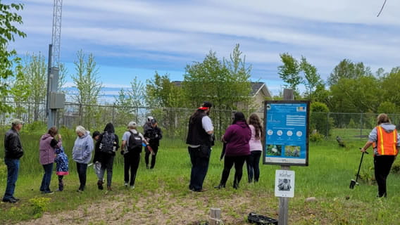 a group of students and chaperones outside preparing to plant