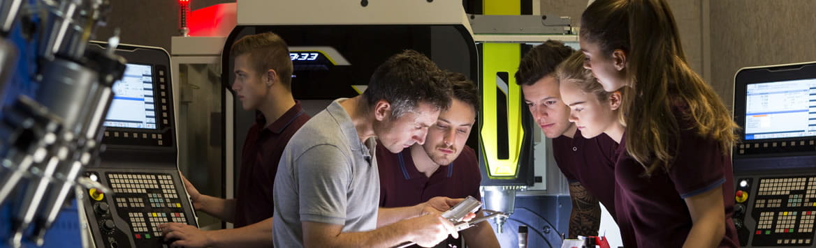 high school students with teacher learning in engineering setting