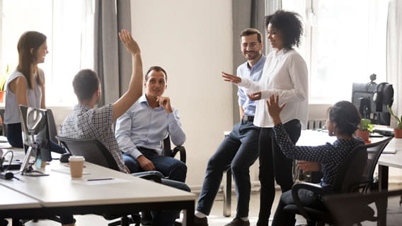 Five people in an office collaboration setting discussing something