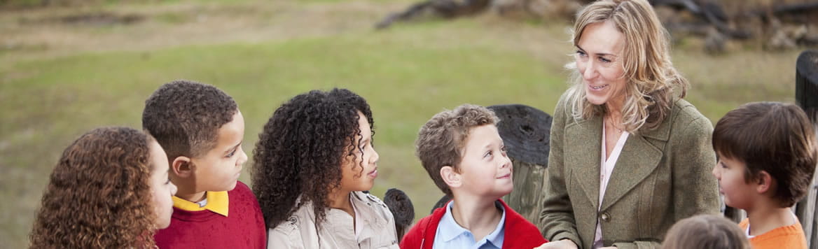 teacher outside talking to young students