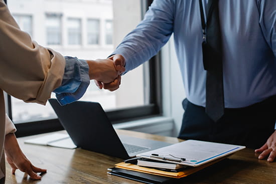 Man in blue shirt shaking woman hand
