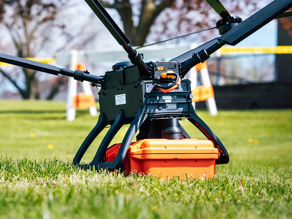 Drone on the ground holding a package.