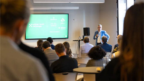 Speaker presenting to an audience at an Urban Tech Xchange event in a conference room.