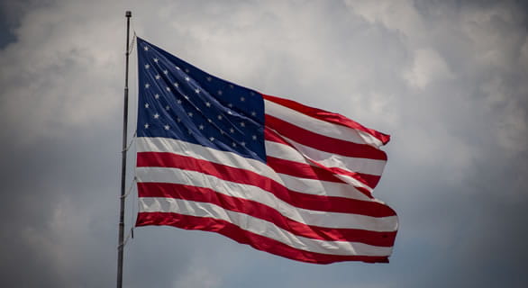 American flag flying against a cloudy sky