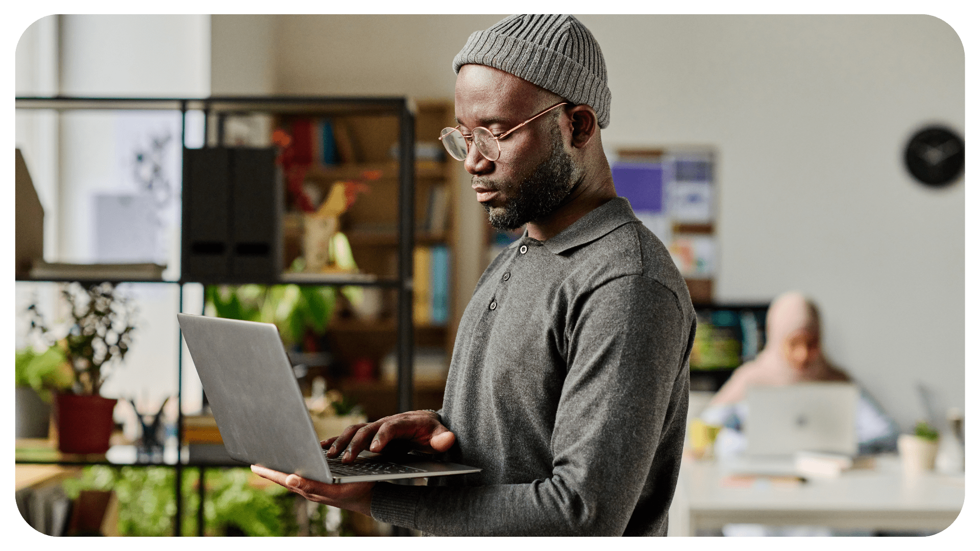 A person is standing while typing on a computer.