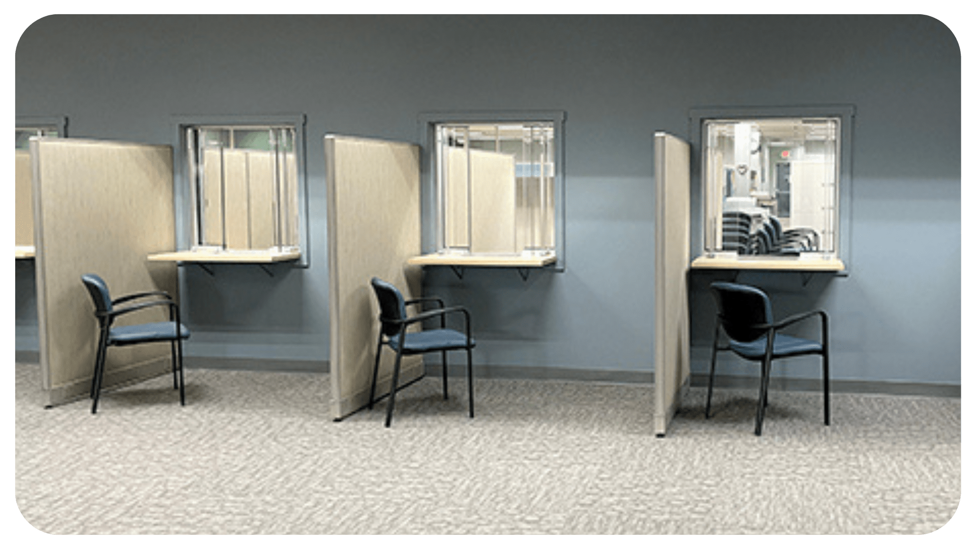 An image of three empty chairs in front of glass windows. The walls are a freshly painted blue.
