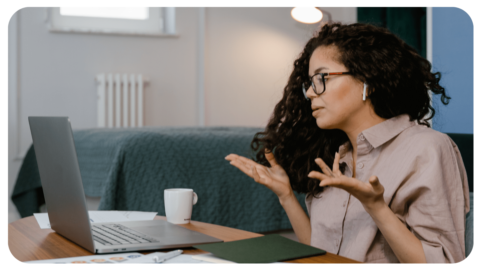 A person is looking at a laptop in front of them. They are speaking with their hands.
