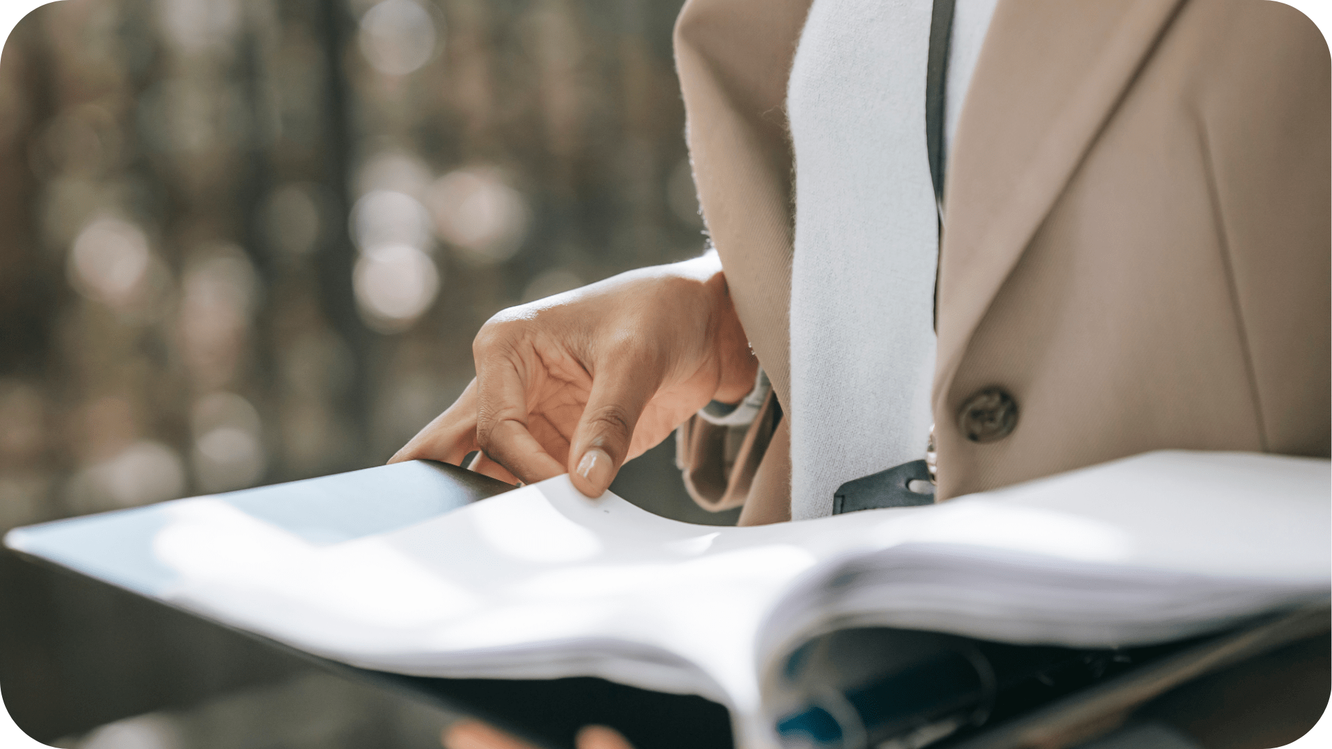 A person is holding a binder and flipping through the pages.