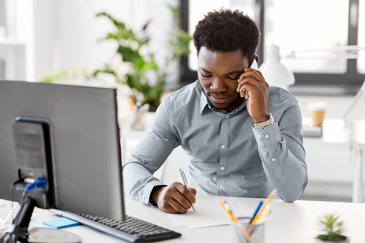 man at computer on phone
