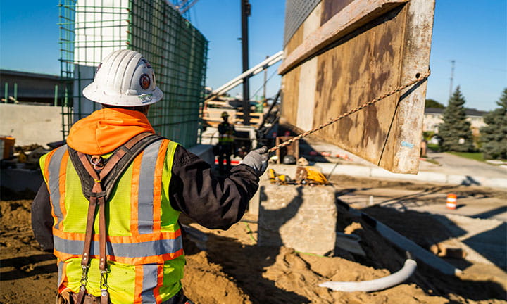 Constuction workers outside moving foundation parts for a building